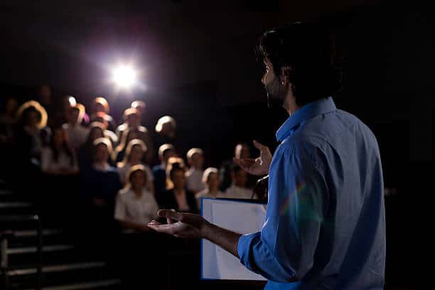 Man standing on stage in front of a audience